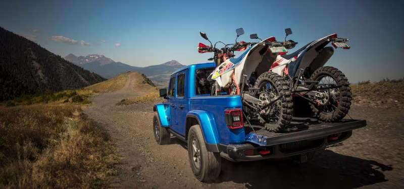 A rear exterior view of the 2025 Jeep Gladiator hauling two motorcycles in the truck bed