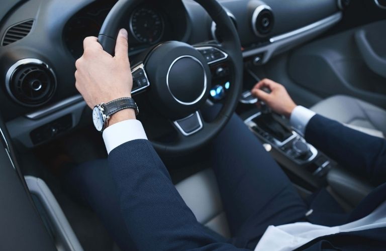 Hands of a man on a steering wheel