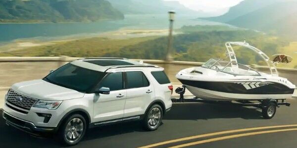 White 2019 Ford Explorer Platinum towing boat on mountainous road