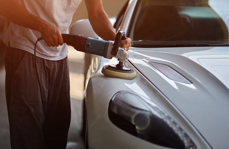 a technician detailing a McLaren