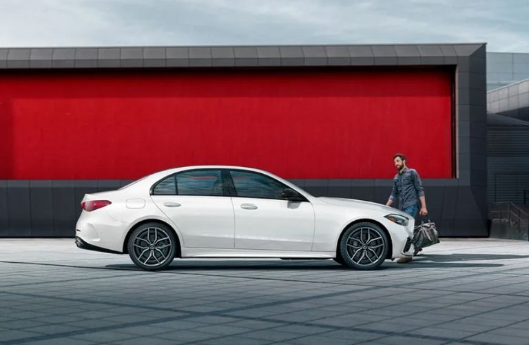 a man walking towards a 2025 Mercedes-Benz C 300 4MATIC® Sedan