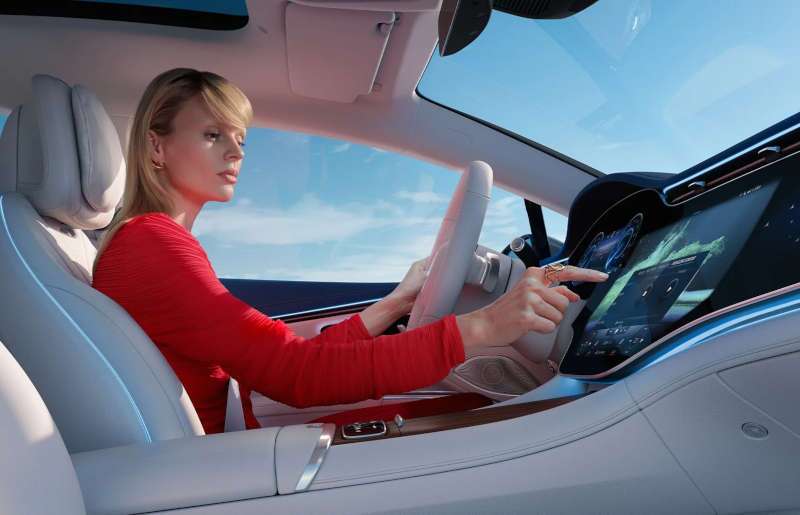 A woman using the large infotainment screen in the EQS 450+