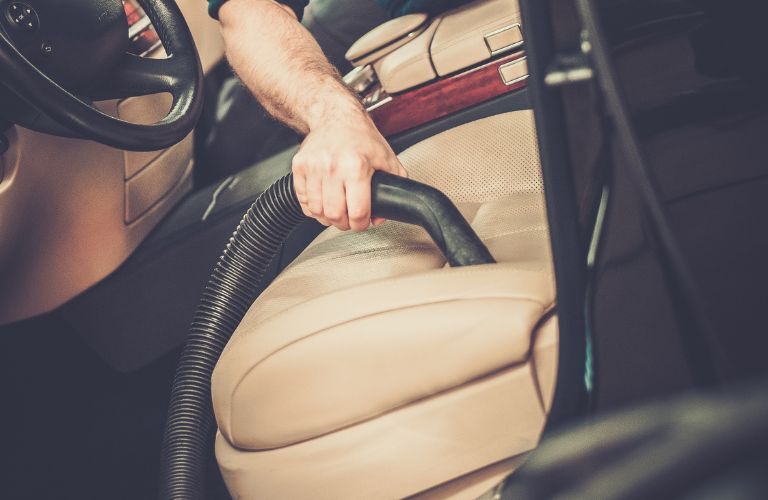 Technician cleaning the interior seating in a car