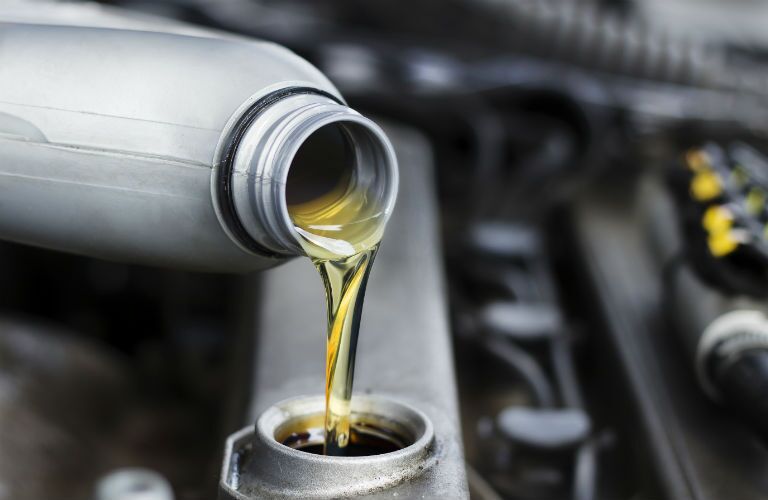 Oil pouring from bottle into engine