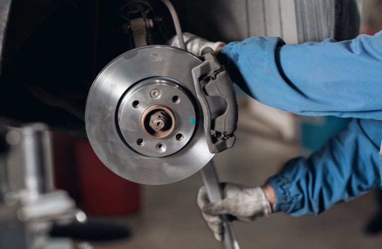Technician servicing brake calipers and brake rotors