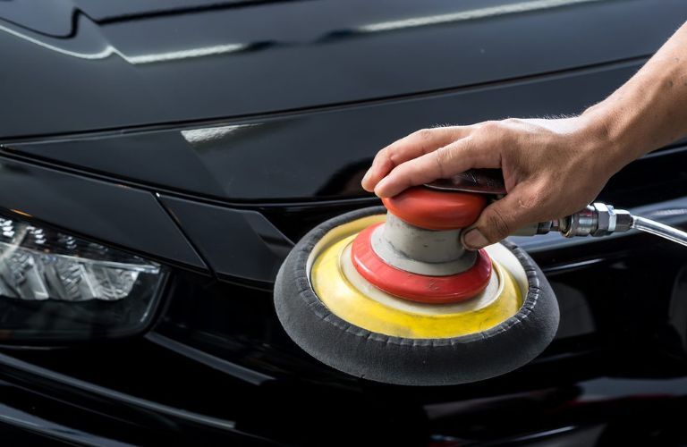 technician waxing a vehicle