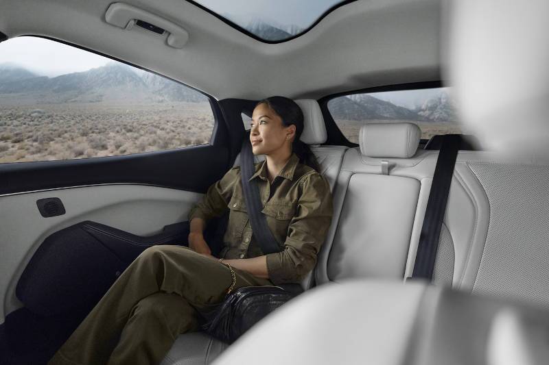 A woman in the rear seat of the 2024 Mustang Mach E Premium near Atlanta, GA.