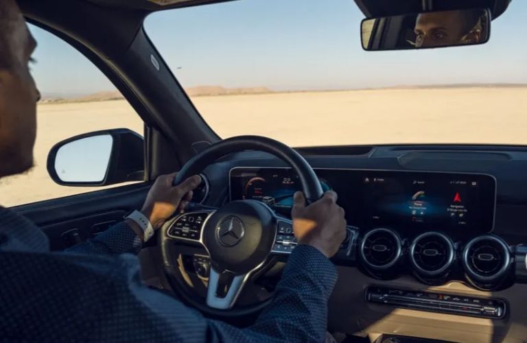 a man driving a certified pre-owned Mercedes-Benz vehicle