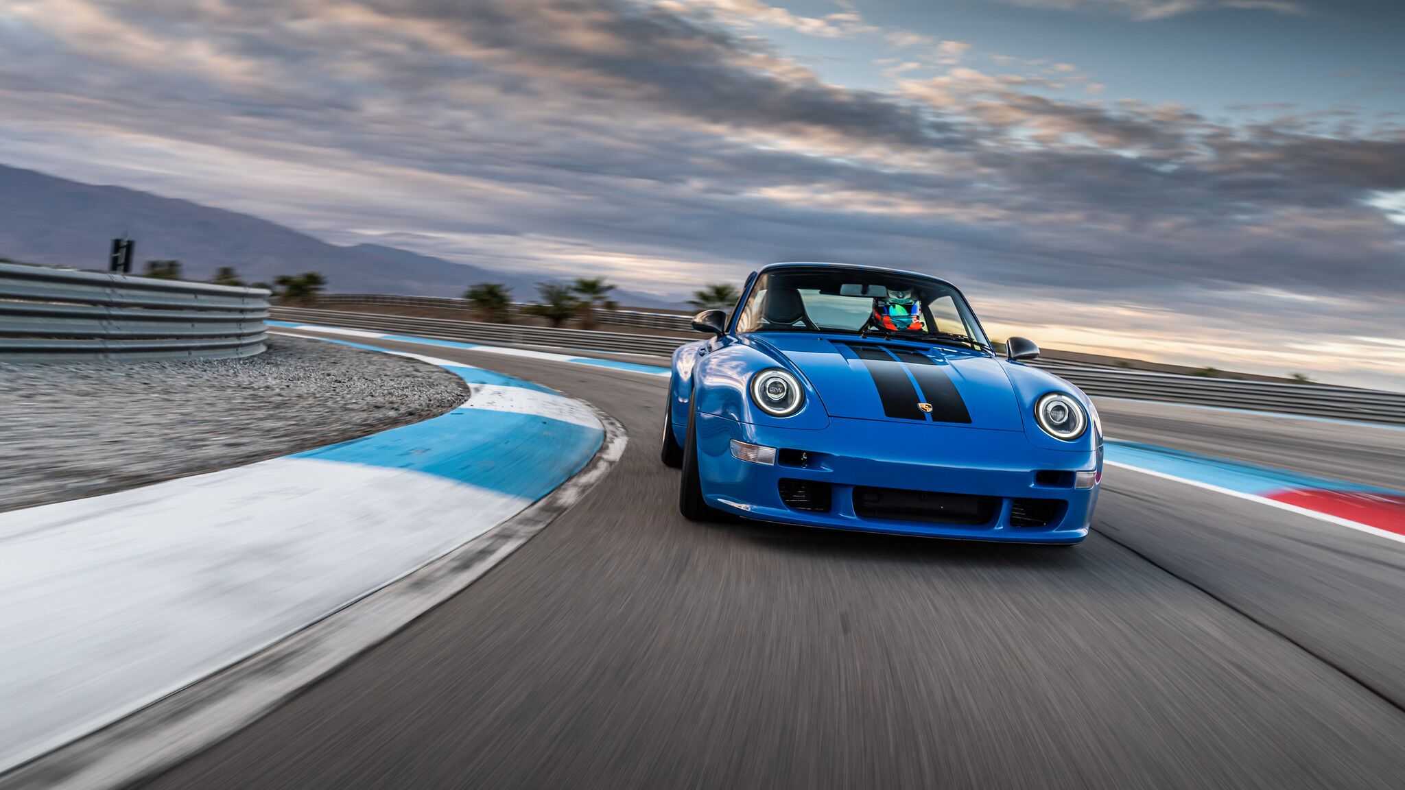 blue Porsche Coupe front view on a track