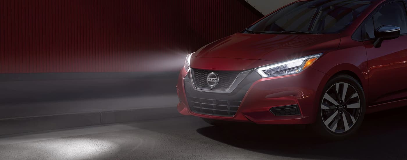 Red 2022 Nissan Versa parked at night near a dealer with used cars for sale near Bayonne