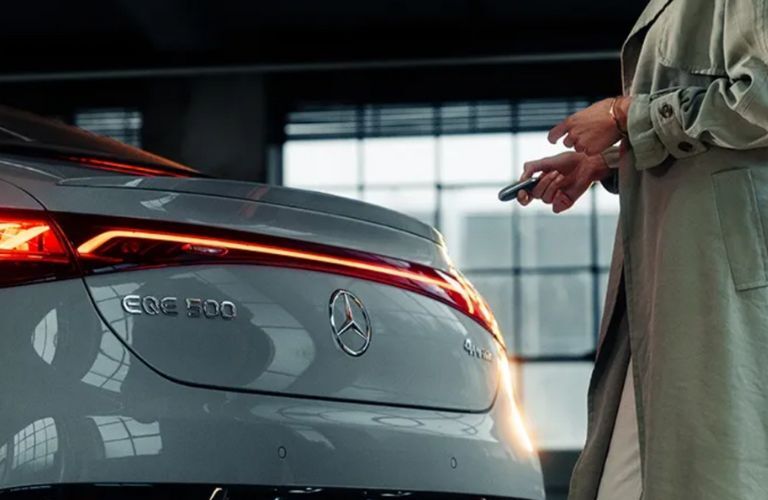 close up of a Mercedes-Benz hood and a person holding its key