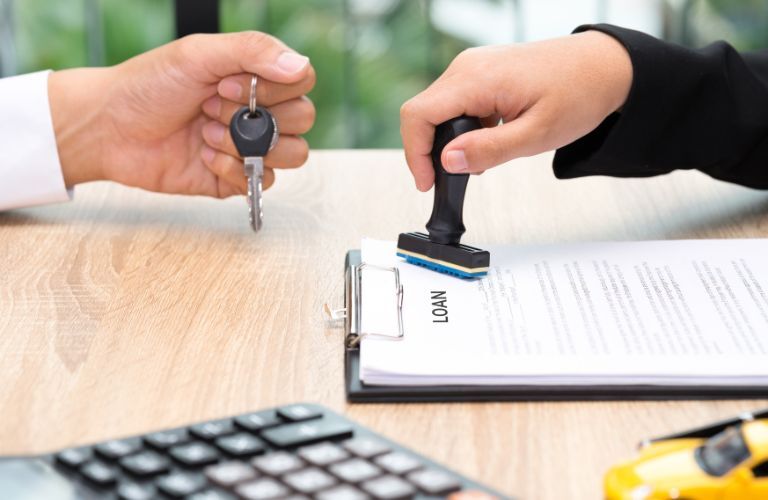 Hand of a man holding keys and anothe hand holding a stamp