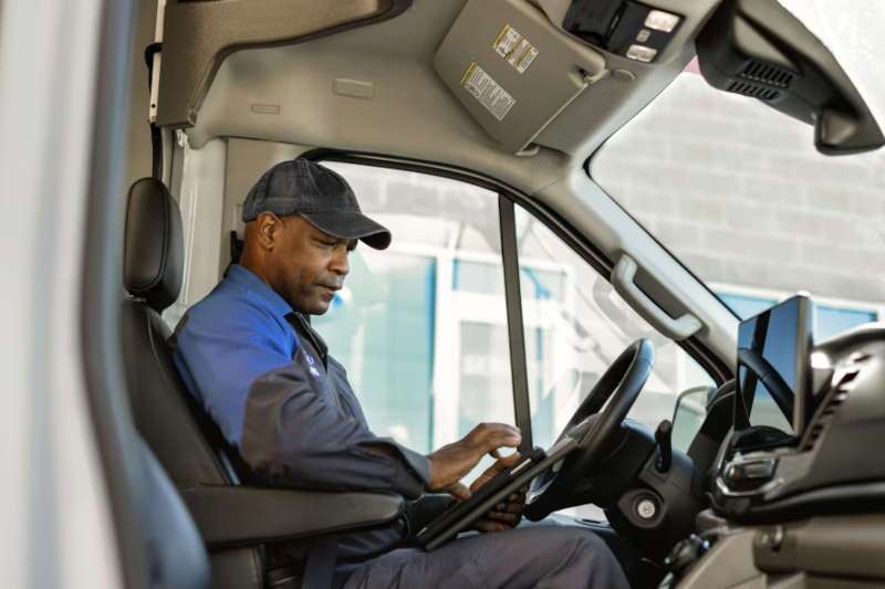 A driver checking his route in the 2026 Ford E-Transit Cutaway