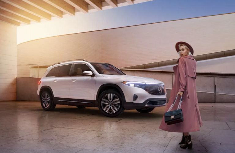 a woman posing in front of a 2025 Mercedes-Benz EQB SUV 
