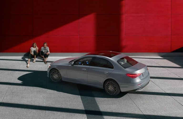 two people sitting next to a 2025 Mercedes-Benz C 300 Sedan