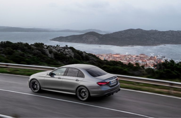 2021 MB E-Class exterior back fascia driver side on highway overlooking city and ocean