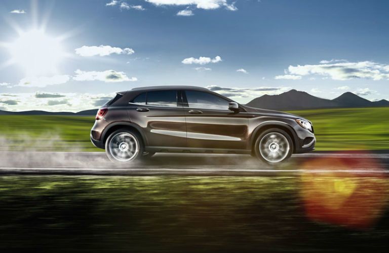 2017 Mercedes-Benz GLA driving past mountains and green grass on a sunny day