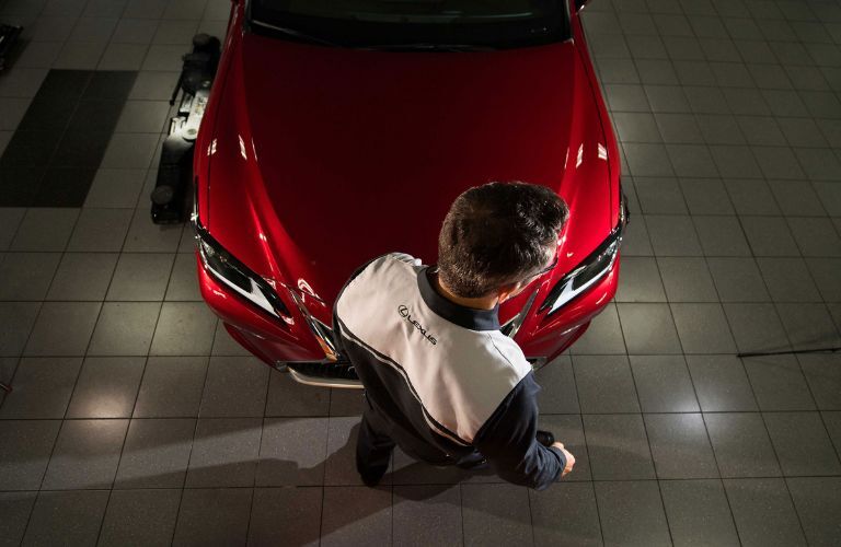 a man standing in front of a used Lexus