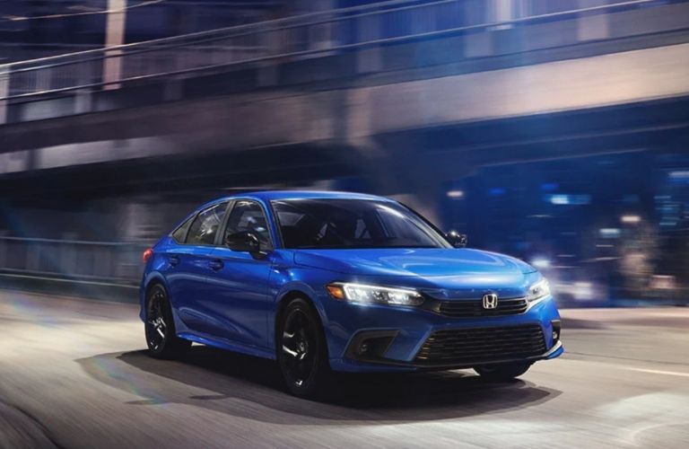 Honda Civic sedan on a city road at night