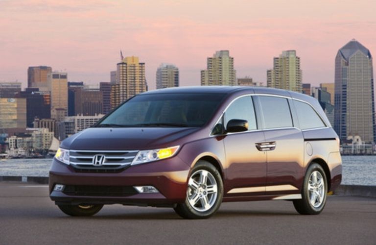 A 2013 Honda Odyssey backdropped by a city skyline