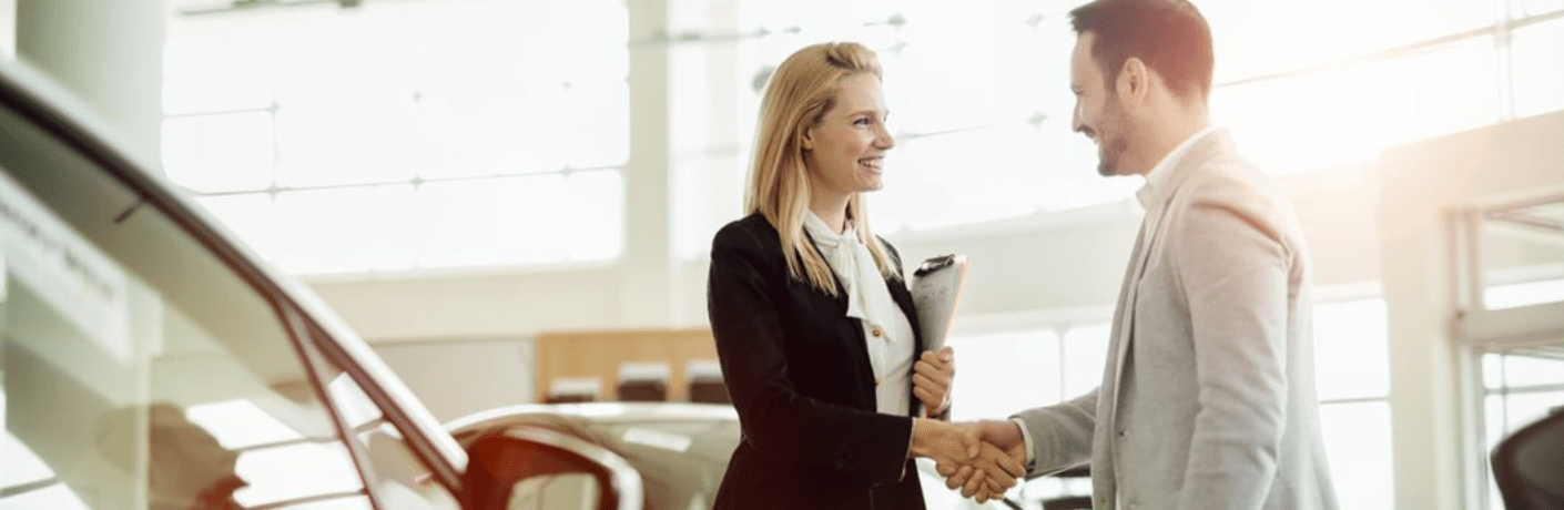 An employee with a customer at a dealership