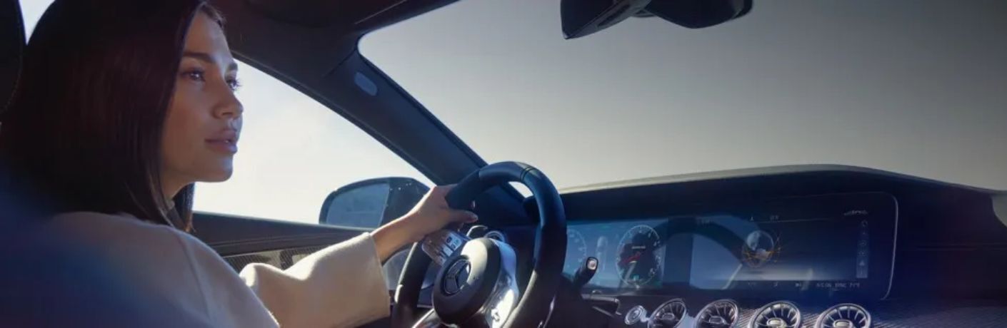A woman driving a Mercedes-Benz vehicle