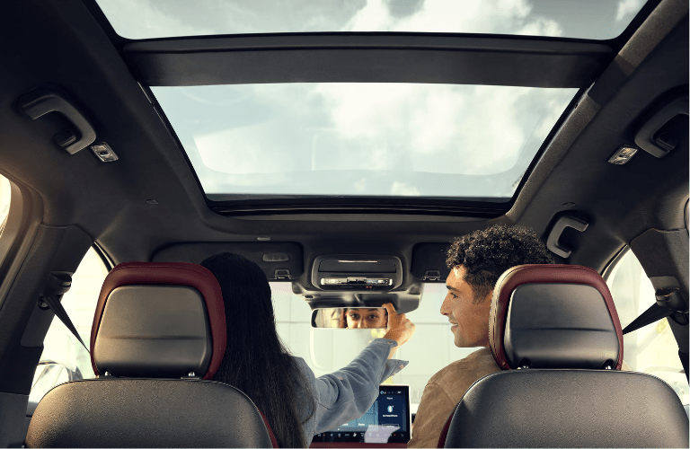 A woman adjusting the rear-view mirror in the 2025 Lincoln Corsair