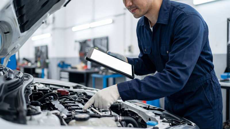 A mechanic checking the engine on a Mercedes-Benz