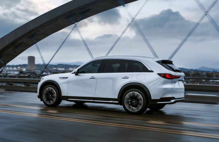 Rear view of the 2024 Mazda CX-90 driving