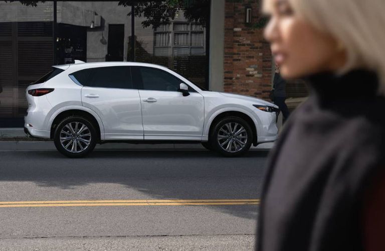 2024 Mazda CX-5 parked with a woman in the foreground