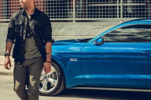 Man walking in front of blue 2019 Ford Mustang GT