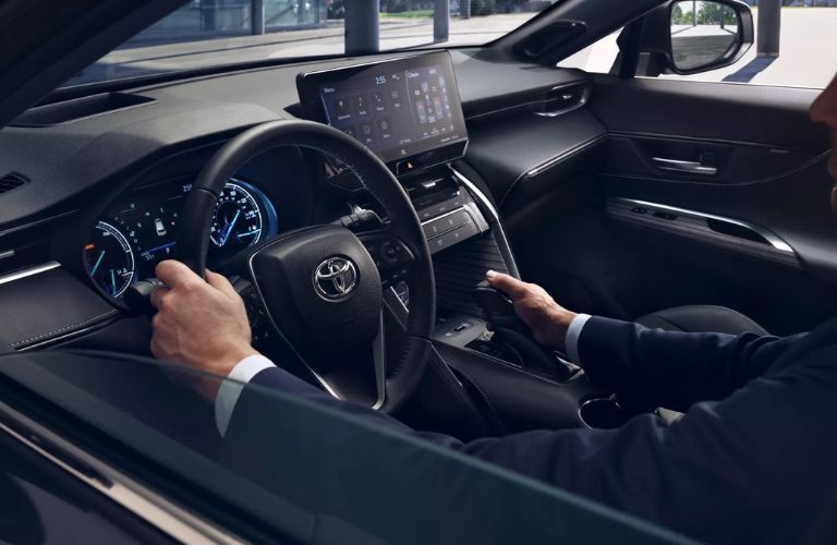 Close up of a man operating the steering wheel of the 2022 Toyota Venza is shown.