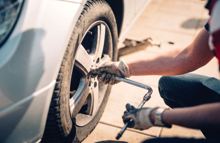 Hands of a mechanic working on the tires of a vehicle