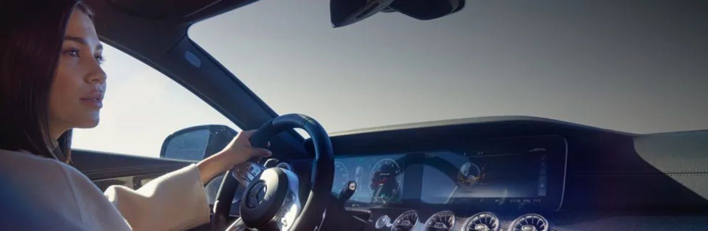 A person driving a Mercedes-Benz car