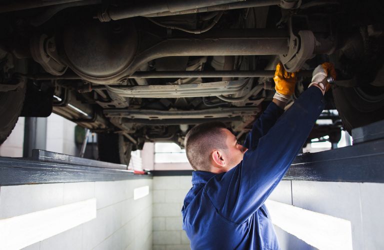 technician working under the hood of the car