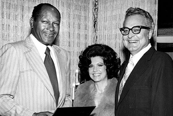 Mayor Tom Bradley congratulating Jane and Bert for recieving the Automotive Retailer of the Year Award