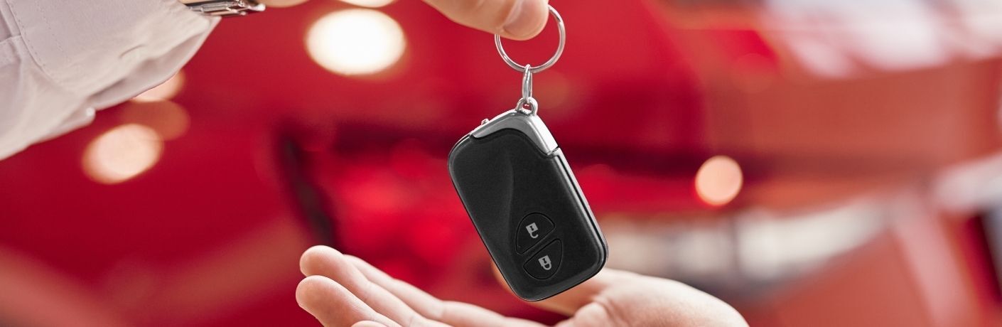 one person handing over the keys of a car to another person