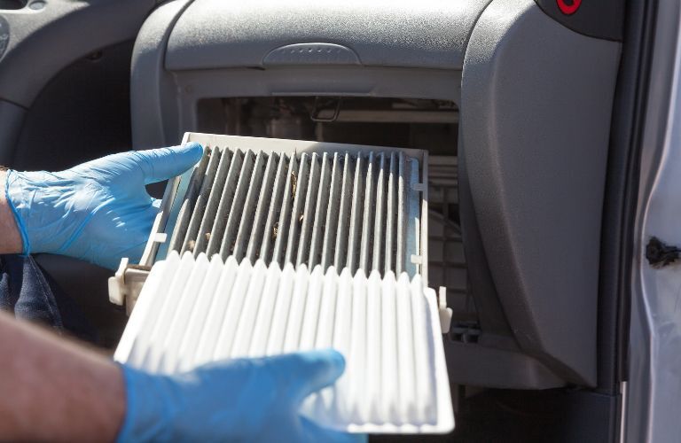 image of a technician changing air filter of a car