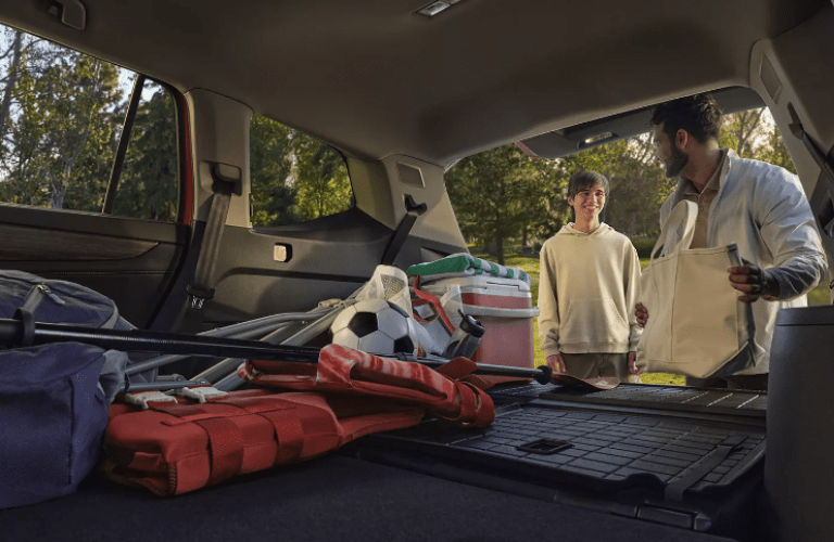 A father and son storing luggage in the 2025 Volkswagen Atlas