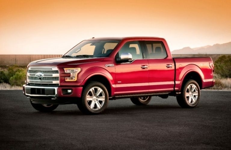 A red 2015 Ford F-150 backdropped by an evening sky