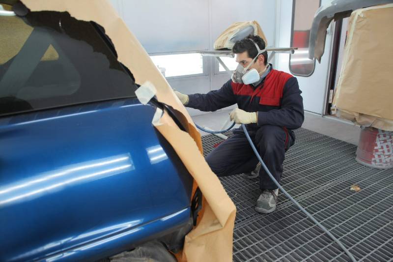 Mechanic Painting a Car