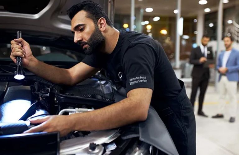 a technician inspecting a Mercedes-Benz