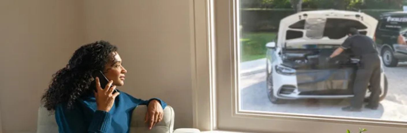 Mercedes-Benz service image with a woman in the foreground and mechanic in the background