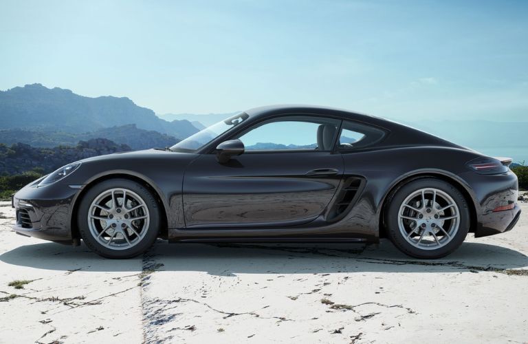Side view of the 2024 Porsche 718 Cayman near a hill range