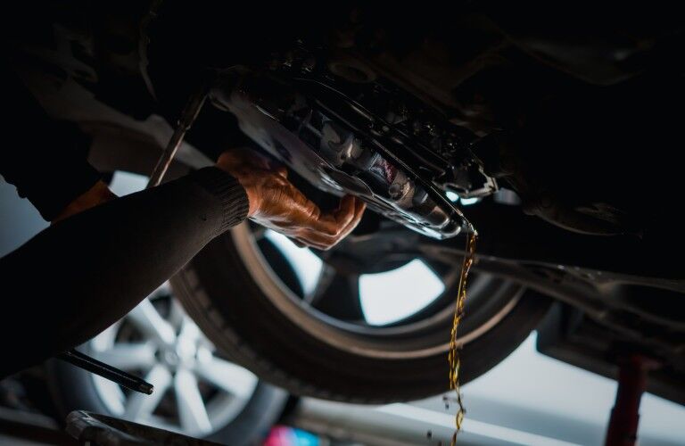 Mechanic changing the transmission fluid in a car