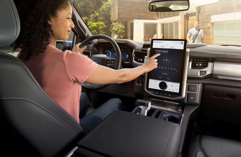 2025 Ford F-150 Lightning with a driver using the touchscreen