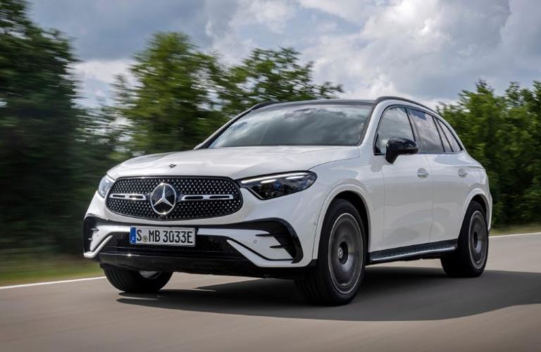 Front view of a white 2022 Mercedes-Benz GLC 300 SUV driving on a road.