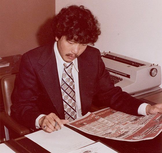 Jack Ong reviewing a newspaper ad