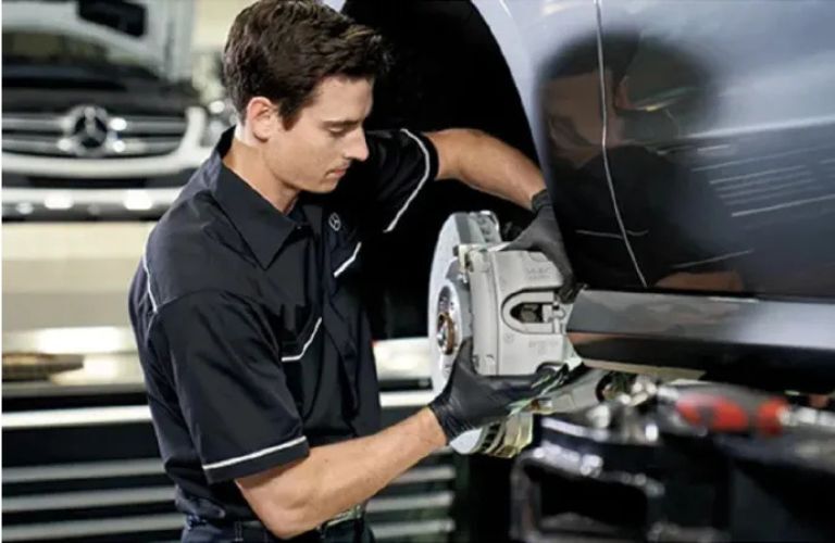 Mercedes-Benz service center with a man fixing a car