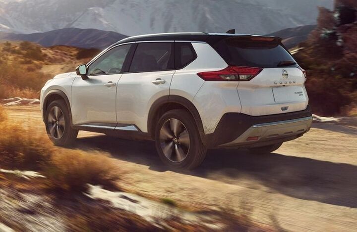 Rear profile of a white 2022 Nissan Rogue on a sandy road_o